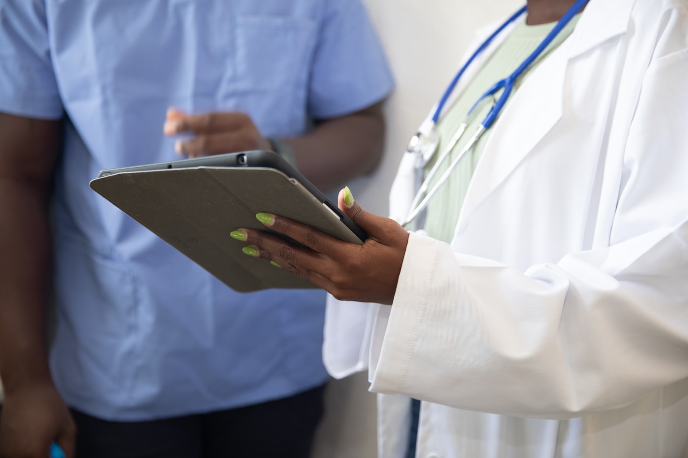 A clinician reviewing information on a tablet with a patient
